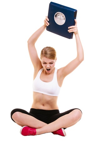 40552252 - slimming diet weight loss. upset frustrated angry young woman girl screaming shouting and throwing weighing scale. healthy lifestyle concept. isolated on white background.